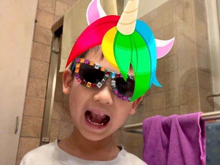 Kid in gem sunglasses with unicorn animation hat