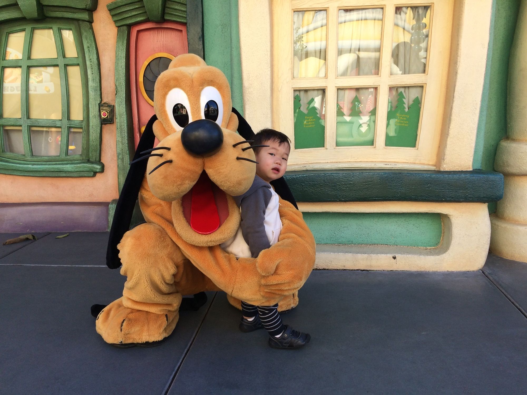 Pluto giving a side-hug to our toddler at Disneyland